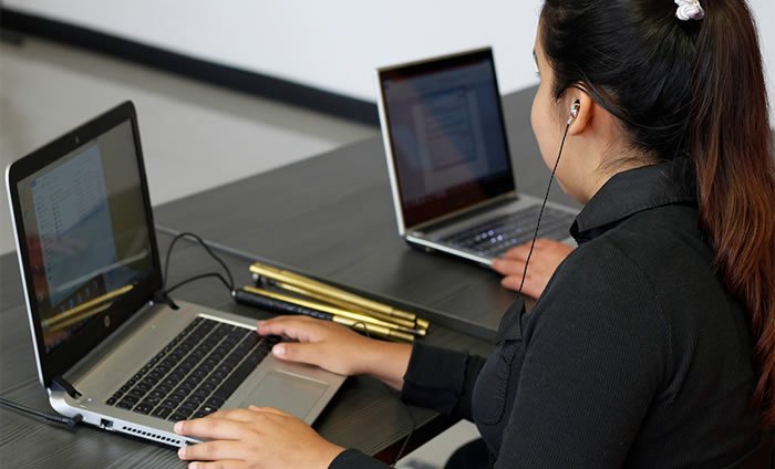 María con discapacidad visual compartiendo datos desde su laptop.